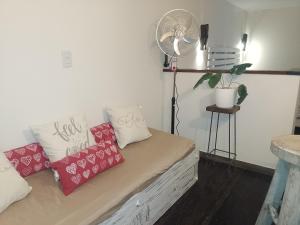 a couch with pillows and a fan in a room at VILLA DE MONTAÑA LOS CHACAYES, Manzano Histórico, Tunuyán in Tunuyán