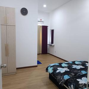una camera da letto con un letto e un orologio a parete di SBB Star Homestay a Sungai Petani Altre 17 foto