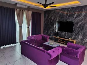 a living room with purple couches and a tv at SBB Star Homestay in Sungai Petani