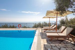 a swimming pool with two lounge chairs and an umbrella at Villa Kalithea in Nisaki