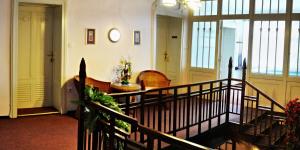 a lobby with a staircase with chairs and a table at Pension Habermannova Vila in Bludov