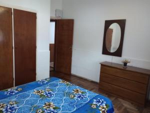 1 dormitorio con cama, tocador y espejo en Casa familiar de verano San Carlos en Mar del Plata