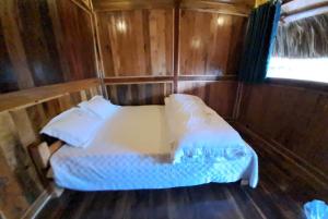 Hòa Bình的住宿－Homestay Highland Hmong，木制客房内的一间卧室,配有一张床