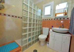 y baño con aseo, lavabo y espejo. en Lovely 3-Bed Bungalow in Camposol Mazarron Spain, en Mazarrón