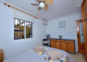 una camera con letto e ventilatore a soffitto di Lovely 3-Bed Bungalow in Camposol Mazarron Spain a Mazarrón