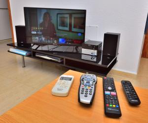 three remote controls sitting on a table in front of a tv at CamposolBungalow 3bedroom Bbq Ac Tv Wifi in Mazarrón