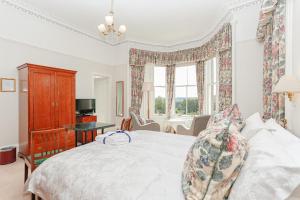 a bedroom with a bed and a desk and a television at Arden House B&B and Self-Catering in Callander