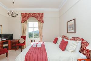 a bedroom with a bed and a desk and a window at Arden House B&B and Self-Catering in Callander