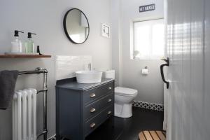 un bagno con lavandino, WC e specchio di The Lambing Shed, Cornwall ad Altarnun Altre 29 foto