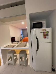eine Küche mit einem Kühlschrank und 2 Hockern in der Unterkunft Monoambiente Evans in Ciudad Lujan de Cuyo