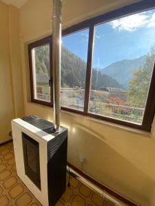 a room with a television and a large window at Lo Bec in Ronco Canavese