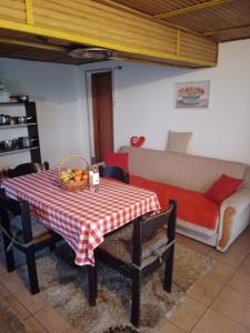 ein Wohnzimmer mit einem Tisch und einem Sofa in der Unterkunft Blossom Cottage in Laktaši