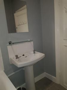 a bathroom with a white sink and a mirror at London. Gorgeous 2 bed flat near Olympic Park. in London