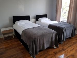 two beds sitting next to each other in a room at London. Gorgeous 2 bed flat near Olympic Park. in London