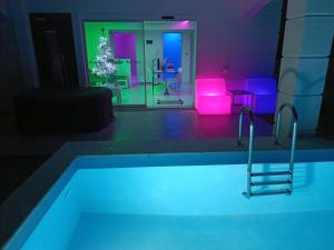 Habitación con piscina con luces moradas y azules en Alpha Delta Pool Suite, en Palaión Tsiflíkion