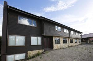 a black building with windows on the side of it at Rumbo Sur Apart Hotel in Coihaique