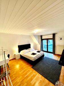 um quarto com uma cama grande e piso em madeira em Praktisches Zimmer im Großen Haus mit garten em Dusseldorf