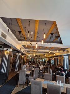 科帕奥尼克Apartmani Srna Milmari的有桌椅和坐在桌旁的人们的餐厅