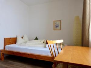 a bed in a room with a table and a chair at Berghotel Franzenshöhe in Trafoi