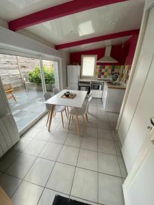 a kitchen with a table and chairs in a room at La Petite Maison Blanche 