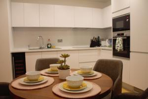 una cocina con una mesa de madera con tazas y sillas en whats she want-- 2beds 2bath apartment en Birmingham