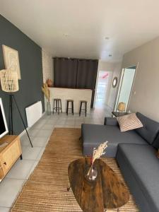 a living room with a couch and a table at La Petite Maison Blanche 