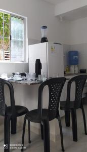 una cocina con 2 sillas y una mesa con barra en COMPLEJO PONTA das BRILLES. DTO. 2., en Barra de Tabatinga