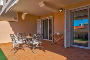 une terrasse couverte avec une table et des chaises. dans l'établissement Modern apartment with large terrasse, bbq, fast wifi, 2 pools, à Puerto de Santiago