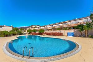 une grande piscine au milieu d'un bâtiment dans l'établissement Modern apartment with large terrasse, bbq, fast wifi, 2 pools, à Puerto de Santiago