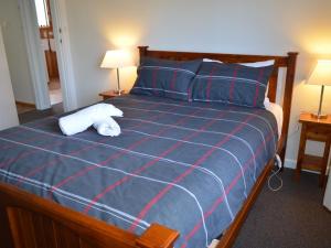 a bedroom with a bed with a blue and red blanket at Freycinet Sands in Coles Bay