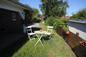 two chairs and a table in a yard at Ferienwohnung Frida in Althagen