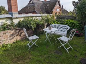 two chairs and a table in a yard at Ferienwohnung Frida in Althagen