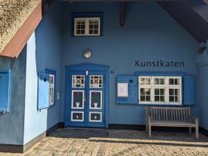 a blue building with a bench in front of it at Ferienwohnung Frida in Althagen +19 photos