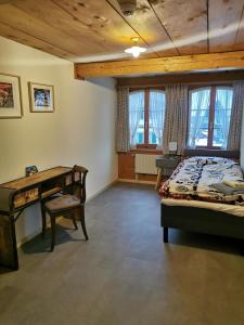 a bedroom with a bed and a desk and windows at Gasthof Kreuz Marbach in Marbach