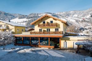 a large house with a balcony in the snow at Das Martell in Sankt Johann im Pongau