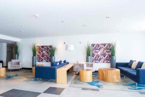 hol z niebieskimi kanapami, stołami i roślinami w obiekcie Sandman Signature Prince George Hotel w mieście Prince George