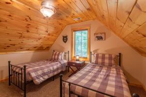 two beds in a room with a wooden ceiling at Laurel Creek Lodge in Banner Elk +38 photos