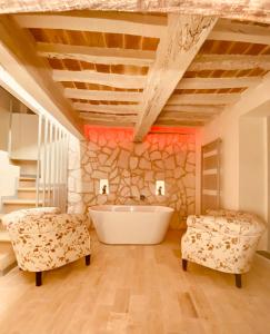 a bathroom with a tub and a stone wall at Vermaaten Boutique Suites Diamond in Todi
