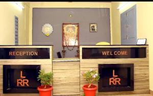 um lobby com uma recepção e um sinal de boas-vindas em LRR TOWERS(LODGE) em Dindigul