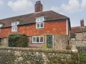 een oud stenen huis achter een stenen muur bij 48 Polecat Cottages in Lewes