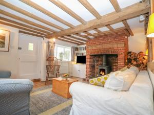 a living room with a couch and a fireplace at 48 Polecat Cottages in Lewes