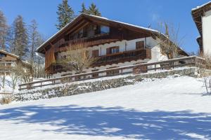 una casa nella neve con una recinzione di Villa Marianna - Stayincortina a Cortina dʼAmpezzo