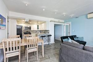 a kitchen and living room with a table and a couch at Ilikai Apt 1822 - Newly Renovated 2BR 2BA Modern Unit with Stunning Ocean & Harbor Views in Honolulu