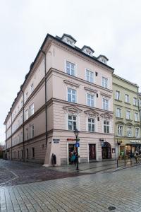 - un grand bâtiment blanc dans une rue de la ville dans l'établissement Crystal House - LoftAffair Collection, à Cracovie