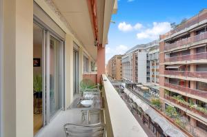 - un balcon avec une table et des chaises dans un bâtiment dans l'établissement BEL CANTO - Charmant appartement de 50 m2, à Toulouse