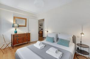 - une chambre avec 2 lits dotés d'oreillers bleus et blancs dans l'établissement BEL CANTO - Charmant appartement de 50 m2, à Toulouse