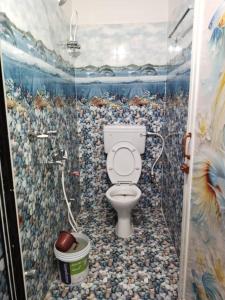 a bathroom with a toilet in a tiled room at Goroomgo Ray Home Stay Swargadwar Puri in Puri