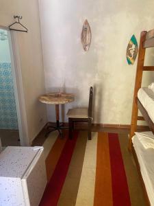 um quarto com uma mesa, uma mesa e uma cadeira em Casa da Si Hostel em Ubatuba