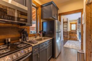 Una cocina con frigorífico de acero inoxidable y fregadero. en Hook Wine and Sinker at Eagles Nest, en Banner Elk