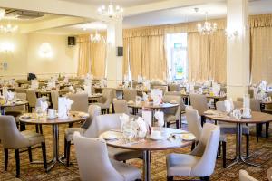 a dining room with tables and chairs and chandeliers at Devonshire Hotel in Torquay